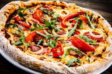 Pizza with pepper,salami and champignon on wooden table