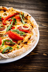 Pizza with pepper,salami and champignon on wooden table