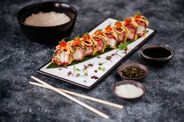 Various kinds of sushi served on black stone
