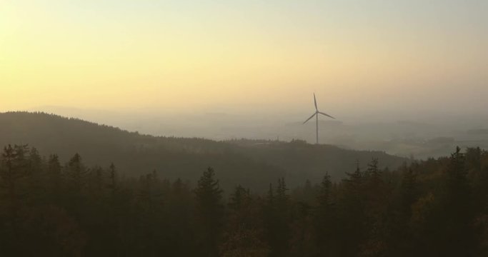 Windrad in diesiger Waldlandschaft im Sonnenuntergang Weitwinkel