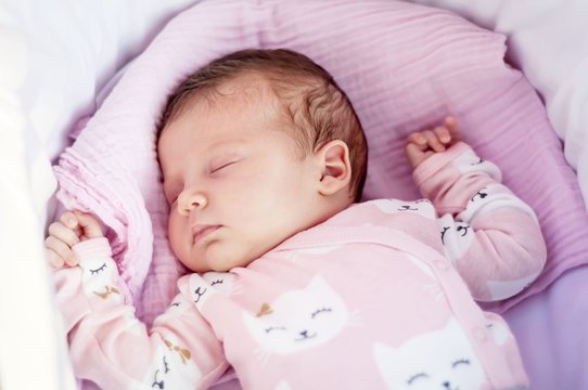 Sweet Caucasian newborn baby sleeping in the cradle or baby carriage. Baby sleep concept stock image.