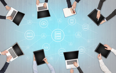 Group of people with devices in hands working in team on tablets, laptops with office, connection,...