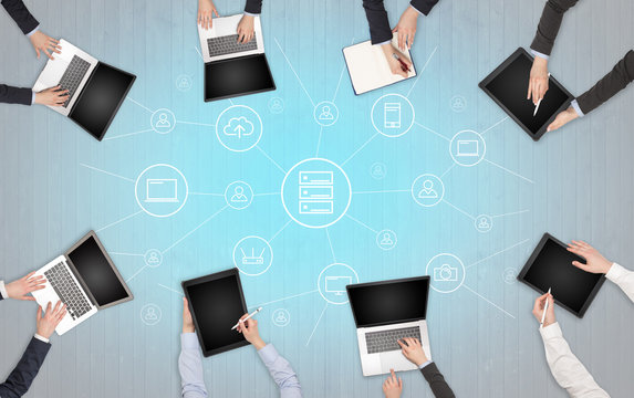 Group of people with devices in hands working in team on tablets, laptops with office, connection, cloud concept
