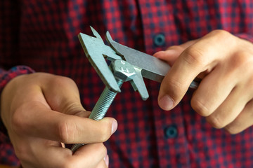 close up man hands hold the caliper and measure the metal pieces f