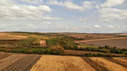 Aerial view of countryside in autumn with yellow fields and clouds in the background