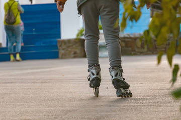 little kid riding the roller skates in the street f