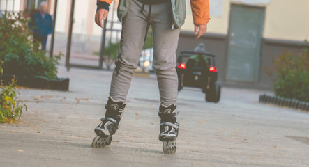 little kid riding the roller skates in the street f