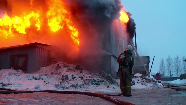 Firemen is fighting with fire. Fighting fire with an open flame. The fire in the building.
