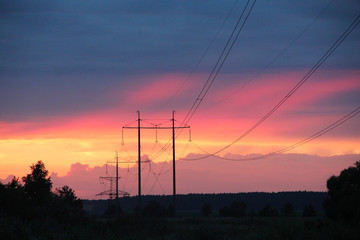 Fototapeta na wymiar Sunset with crimson clouds and high-voltage line