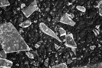 Black and white shattered glass on asphalt on top