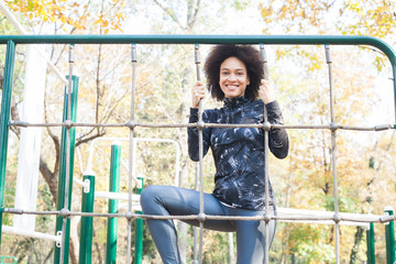 Fototapeta premium Smiling Mixed Race Young Woman Exercise At Outdoor Fitness Park