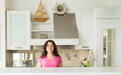 Housewives, emotions and people concept - Happy young woman in the kitchen at home