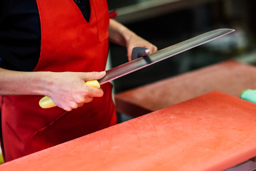 Butcher sharpening a knife in a butcher shop