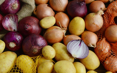 Many Potatoes,Red and yellow onions put mixed together in the floor.
3 vegetables must have in the kitchen.