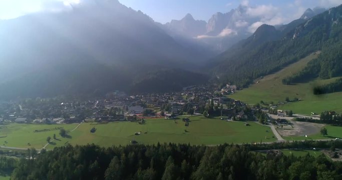 Alpine town, C4K aerial tilt up, drone view of the Kranjska Gora town and Trigolov national park, on a sunny summer day, in the Julian alps, Slovenia