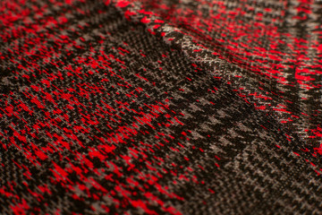 Texture of knitted fabric. Fabric jersey red black creates a textural background. Soft fabric for sewing clothes.