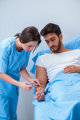 Woman doctor examining male patient in hospital