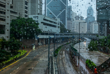 Fototapeta na wymiar Heavy rain, emty streets and a fallen tree in the empty streets of Hong Kong after a storm - 1