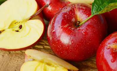 Red apple group with slice and water drop on wooden background.