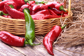 Wicker basket full of fresh red chili peppers.