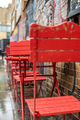 Colorful red chairs in the streets of London under a light rain - 2