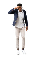 Full body of Handsome african american man wearing a jacket looking far away with hand to look something on white background