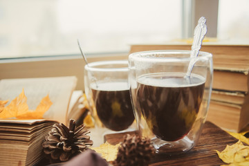 Coffee, books, yellow maple leaves-the concept of comfort and warmth in autumn.
