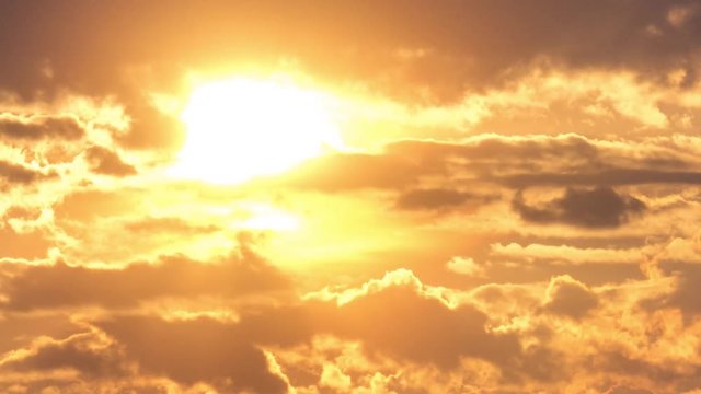 Beautiful yellow cloudscape with large sun. 4K timelapse.