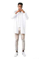 Fototapeta premium Full body of African american doctor showing a sign of closing mouth and silence gesture on white background