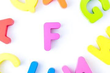 F letters in English made from wood bright colors.