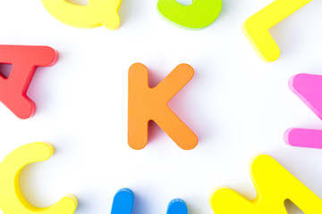 K letters in English made from wood bright colors.