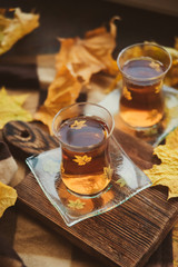 Tea in Turkish cups, books, yellow maple leaves at the window and a warm blanket - the concept of comfort and warmth in autumn.