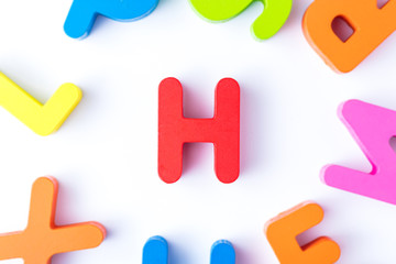 H letters in English made from wood bright colors.