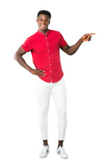 Full body of Young african american man pointing finger to the side and presenting a product while smiling in a confident pose on white background