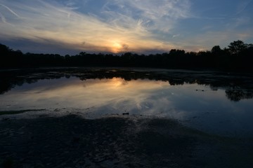 High contrast photograph of a stunning sunset reflected in a polluted. Yields a dystopian atmosphere.