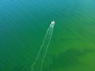 Aerial view on small fishing boat sailing straight at sea waters.