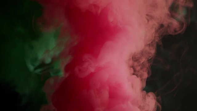 green and pink bomb smoke on black background