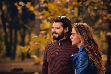 Fototapeta premium Couple in autumn season colored park enjoying outdoors.
