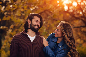 Couple in autumn season colored park enjoying outdoors.