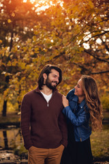 Fototapeta premium Couple in autumn season colored park enjoying outdoors.