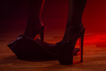 Tanzende Frau in High Heels mit Lederminirock auf dem Parket