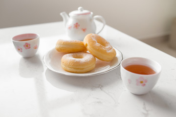 Classic donut. Morning breakfast with tea on table in living room at home.