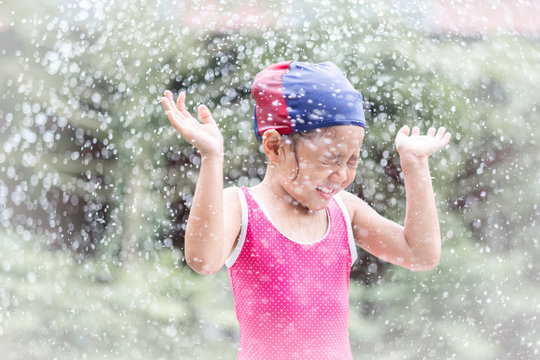 little girl happiness in water spray playing