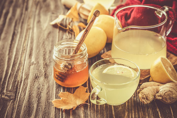 Autumn hot drink - ginger, lemon, honey tea and ingredients, wood back