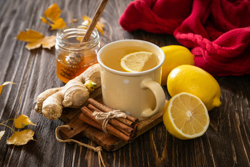 Autumn hot drink - ginger, lemon, honey tea and ingredients, wood back