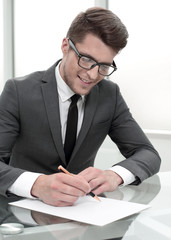 Businessman sitting at office desk signing a contract