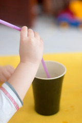 Child hand holding a straw 