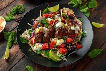 Lamb mint kebabs with flatbread, mix of vegetables, lime and greek yoghurt chilli sauce