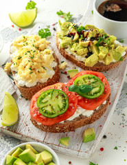 Vegetarian Healthy bread toasts with cottage cheese, heirloom tomatoes, scrambled eggs and avocado