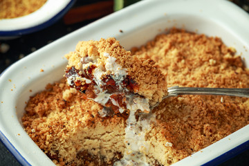 Traditional English apple crumble baked in vintage dish and served with cream